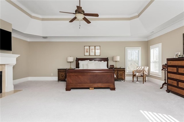 bedroom featuring a raised ceiling, light colored carpet, a fireplace with flush hearth, ornamental molding, and baseboards