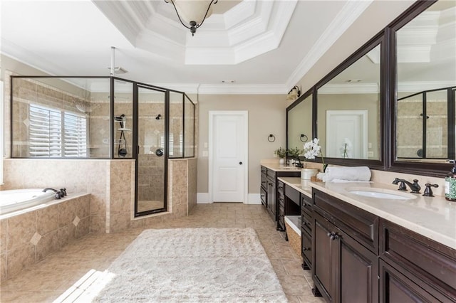 bathroom featuring a tray ceiling, a garden tub, ornamental molding, a stall shower, and vanity