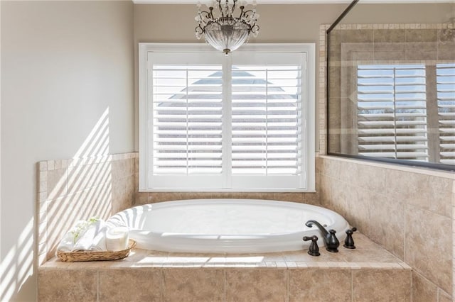 bathroom featuring a bath, an inviting chandelier, and a wealth of natural light