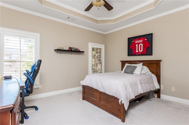 bedroom with light carpet, a tray ceiling, visible vents, and baseboards