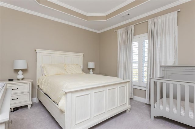 bedroom featuring a tray ceiling, crown molding, visible vents, light carpet, and baseboards