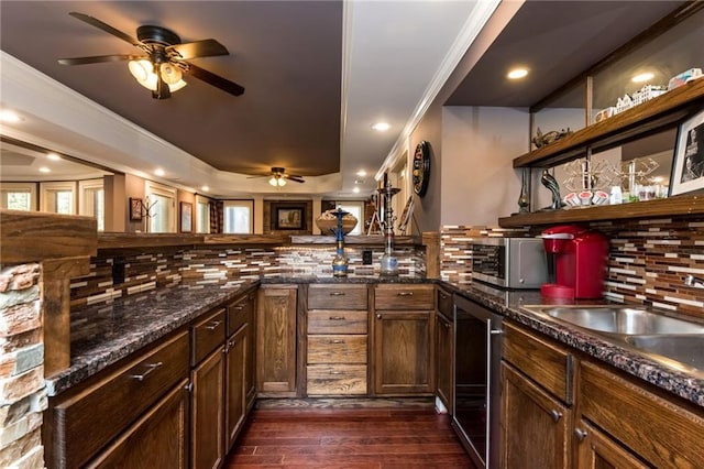 kitchen featuring decorative backsplash, stainless steel microwave, dark wood-type flooring, crown molding, and open shelves