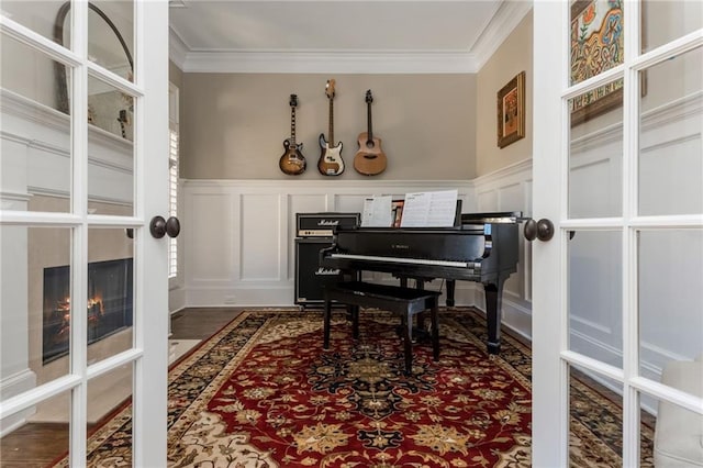 living area featuring a premium fireplace, a decorative wall, and crown molding