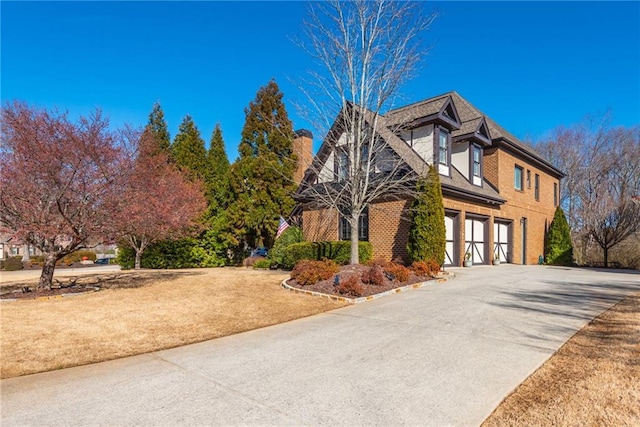 view of front of house featuring driveway, a garage, and brick siding