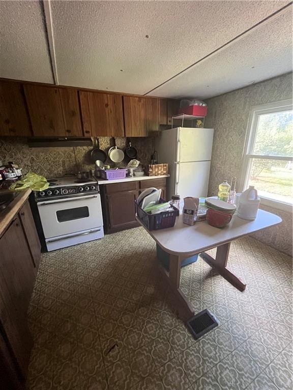 kitchen with a textured ceiling and white appliances