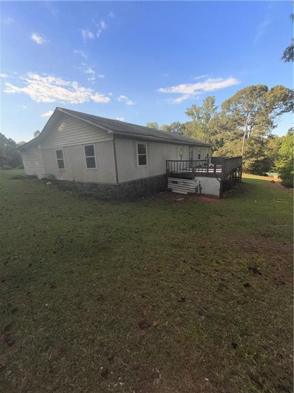 back of house with a deck and a yard