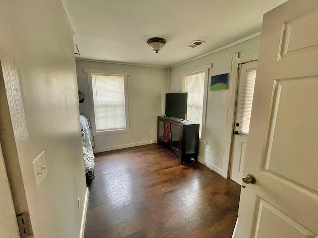 unfurnished living room featuring crown molding and dark hardwood / wood-style floors