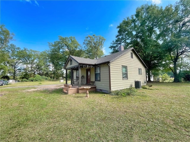 view of home's exterior featuring a porch, a lawn, and central air condition unit