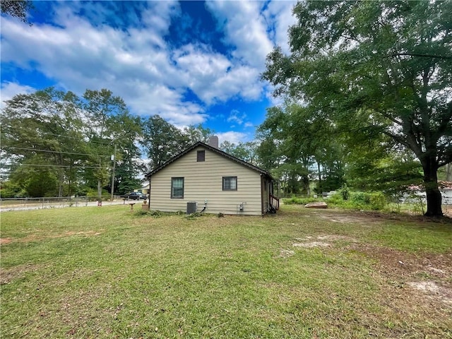 view of home's exterior featuring central AC unit and a yard