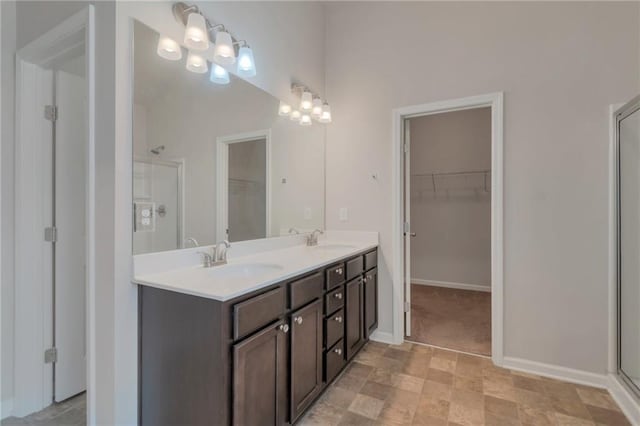 2320 Ivy Birch Ln, Buford, GA 30519 - full bathroom with a walk in closet, double vanity, a shower with shower door, and baseboards
