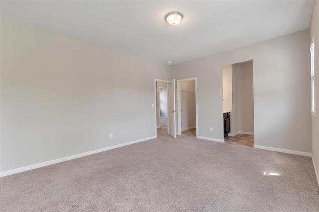 2320 Ivy Birch Ln, Buford, GA 30519 - unfurnished bedroom featuring a walk in closet, light colored carpet, baseboards, and a closet