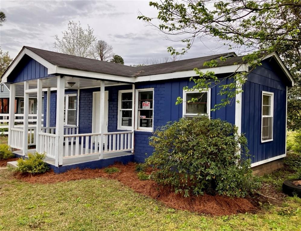 view of front of house with a front yard and covered porch