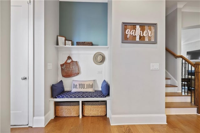 mudroom with wood-type flooring and ornamental molding