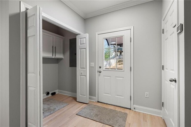 doorway with light hardwood / wood-style floors, ornamental molding, and electric panel