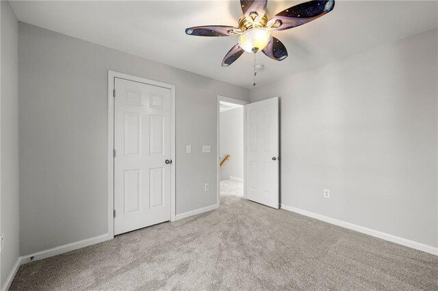 unfurnished bedroom featuring ceiling fan and light colored carpet