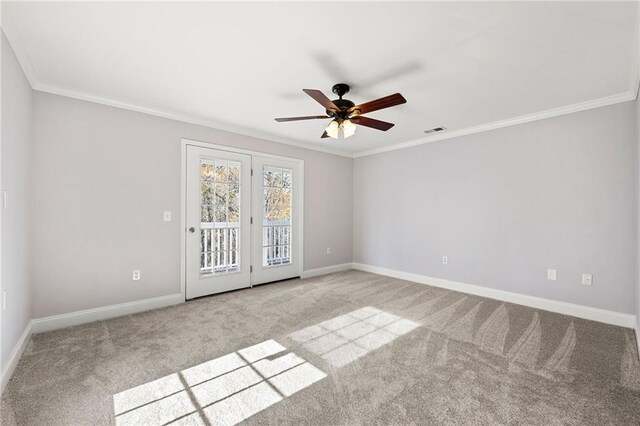 carpeted spare room with ceiling fan and crown molding