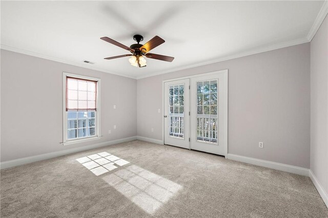 unfurnished room with light carpet, a wealth of natural light, ornamental molding, and ceiling fan