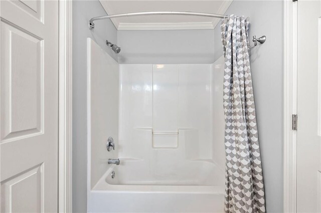 bathroom with crown molding and shower / tub combo with curtain