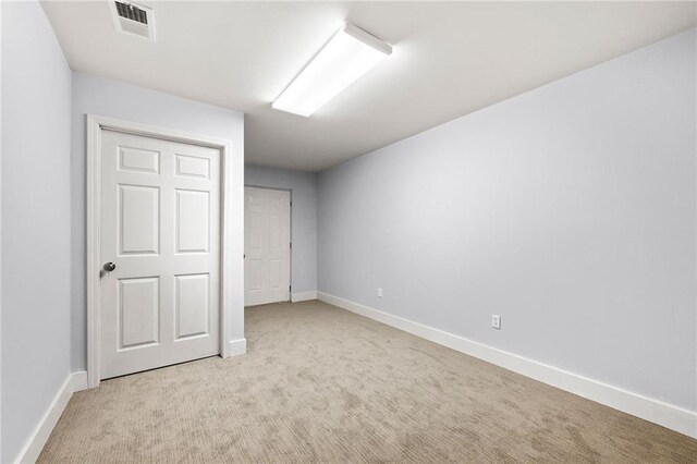 unfurnished bedroom featuring a closet and light colored carpet