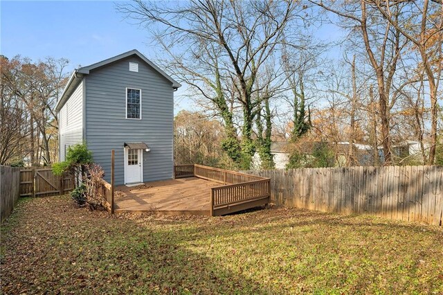 rear view of property with a deck and a yard