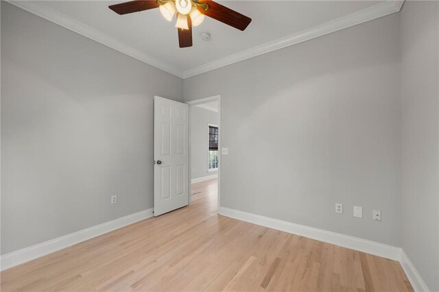 empty room with ceiling fan, light hardwood / wood-style flooring, and crown molding