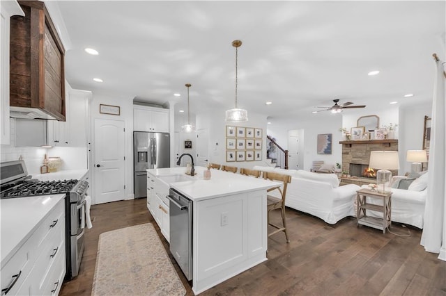104 Woodland Ln, Canton, GA 30114 - kitchen with stainless steel appliances, recessed lighting, a kitchen bar, light countertops, and a stone fireplace
