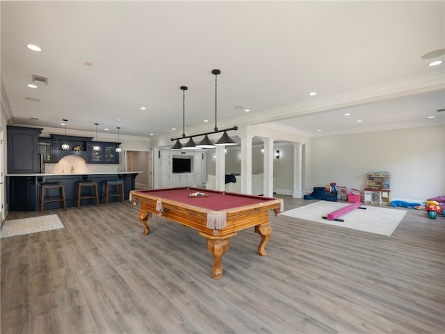 recreation room with billiards, decorative columns, ornamental molding, bar area, and light wood-type flooring