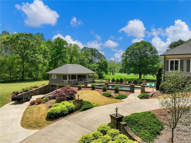 view of community featuring a patio, a swimming pool, and a yard