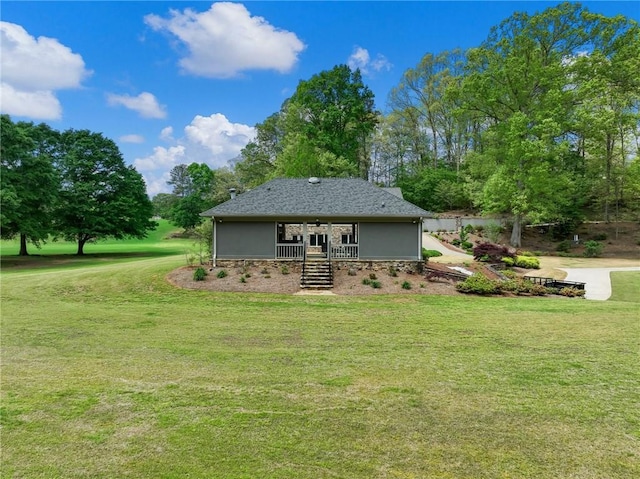 rear view of house featuring a lawn