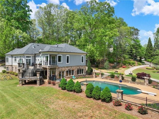 back of property with a lawn, a patio, and a swimming pool side deck