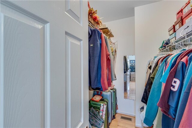 walk in closet with wood finished floors