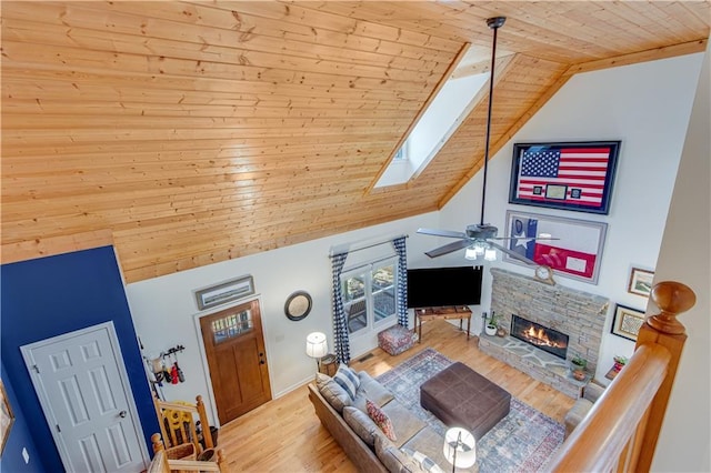 living area featuring wood finished floors, a skylight, a fireplace, wood ceiling, and ceiling fan