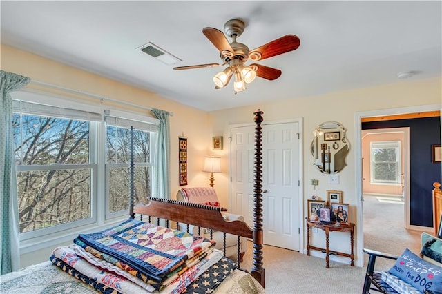 bedroom featuring a ceiling fan, light colored carpet, and visible vents