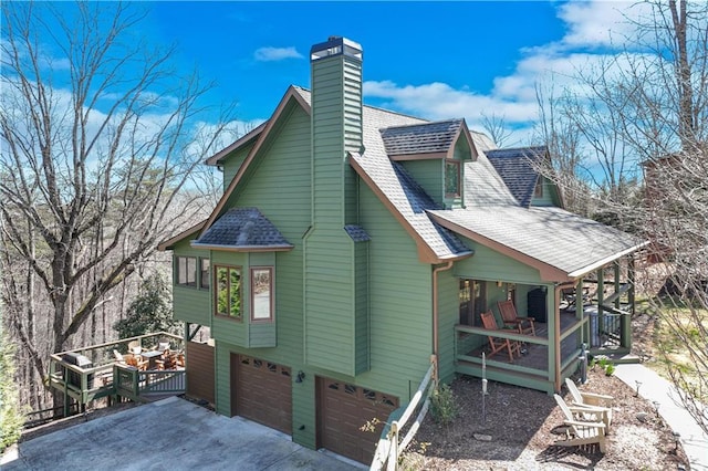 view of property exterior featuring an attached garage, a chimney, driveway, and a shingled roof