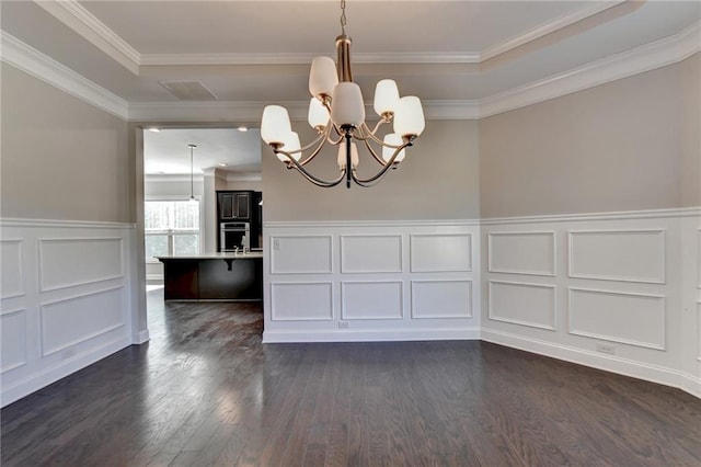 unfurnished dining area featuring an inviting chandelier, crown molding, and dark hardwood / wood-style floors