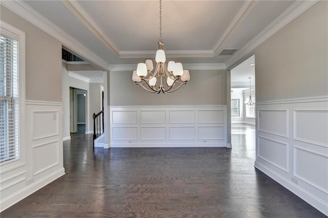 unfurnished dining area with a notable chandelier, a wealth of natural light, dark hardwood / wood-style floors, and a raised ceiling