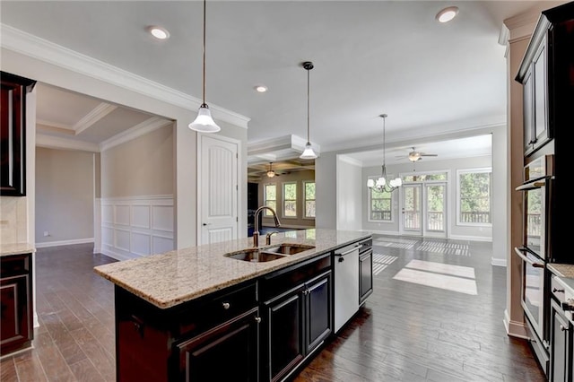 kitchen with sink, a center island with sink, dark hardwood / wood-style floors, pendant lighting, and stainless steel appliances