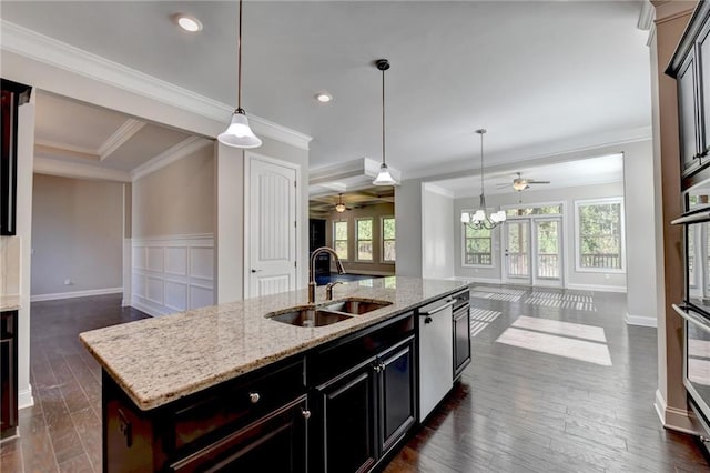 kitchen with sink, a kitchen island with sink, stainless steel appliances, light stone counters, and dark hardwood / wood-style flooring