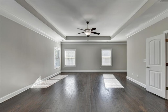 unfurnished room with crown molding, a tray ceiling, dark hardwood / wood-style floors, and ceiling fan