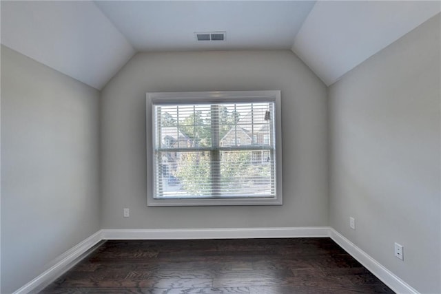 spare room featuring vaulted ceiling and dark hardwood / wood-style flooring