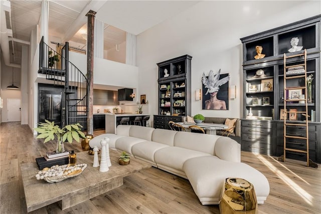 living room with light hardwood / wood-style floors and a high ceiling