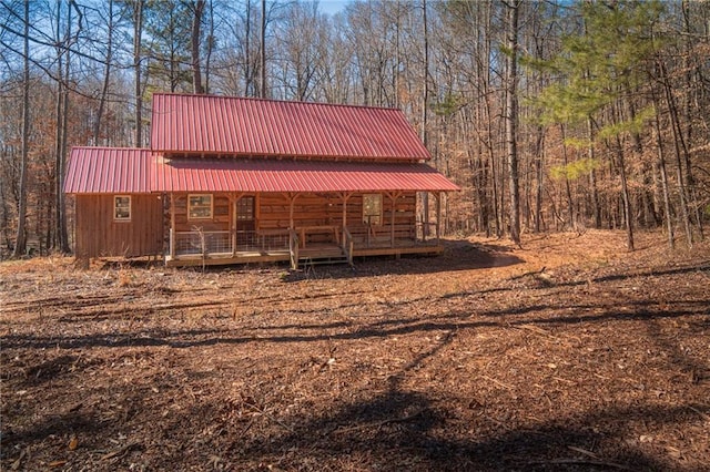 exterior space with metal roof and a forest view