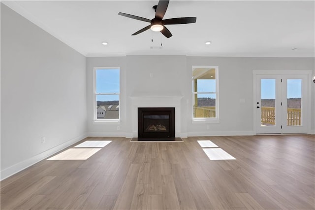 unfurnished living room with light wood-style floors, plenty of natural light, and a fireplace with flush hearth