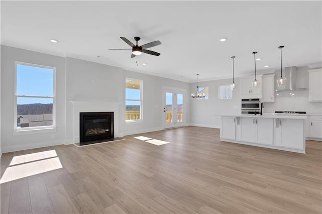 unfurnished living room with recessed lighting, plenty of natural light, and light wood-style flooring