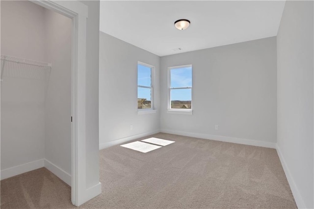 unfurnished bedroom with baseboards, a closet, and light colored carpet