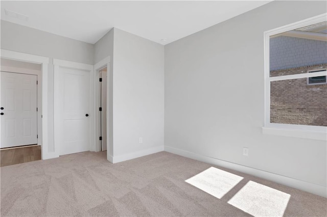 interior space featuring light carpet and baseboards