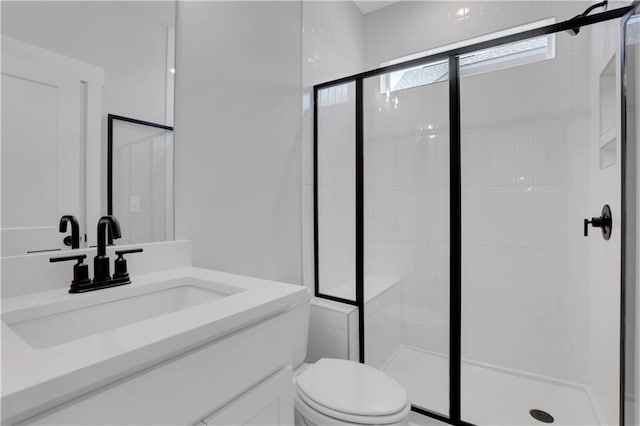 bathroom featuring toilet, a stall shower, and vanity