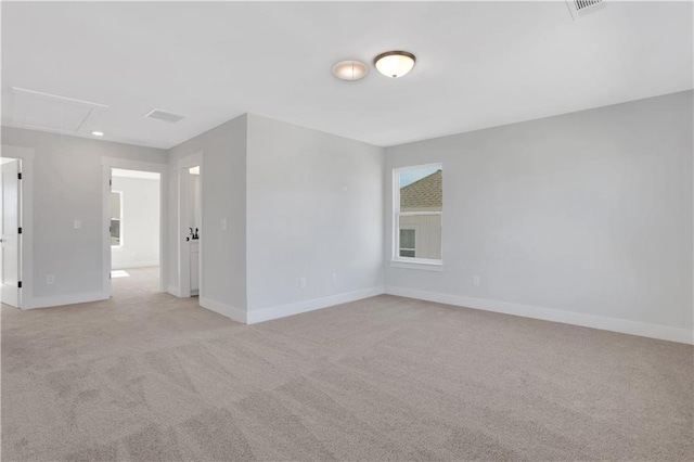 unfurnished room with light colored carpet, visible vents, and baseboards