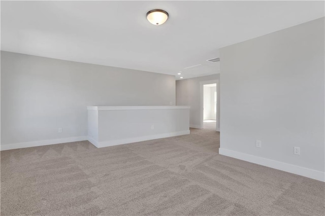 empty room with baseboards and light colored carpet