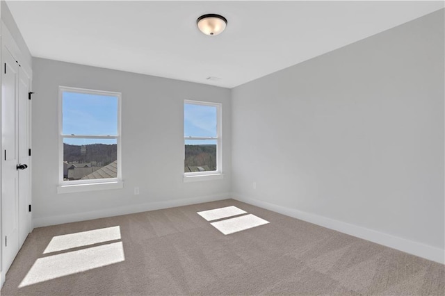 empty room with light carpet and baseboards